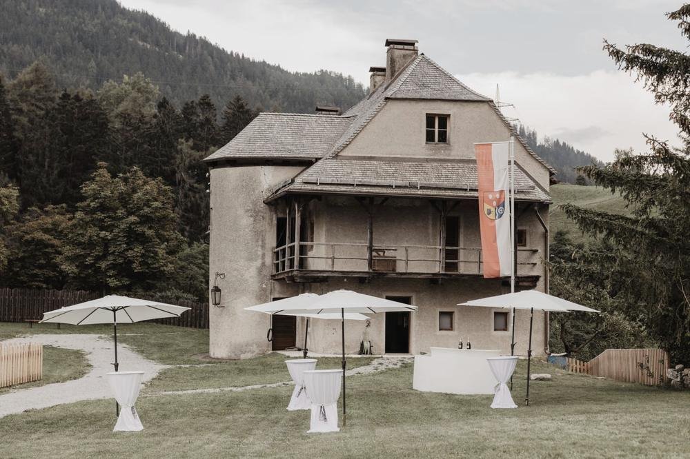 Burg Trautson mit Fahne und Stehtischen auf der Wiese