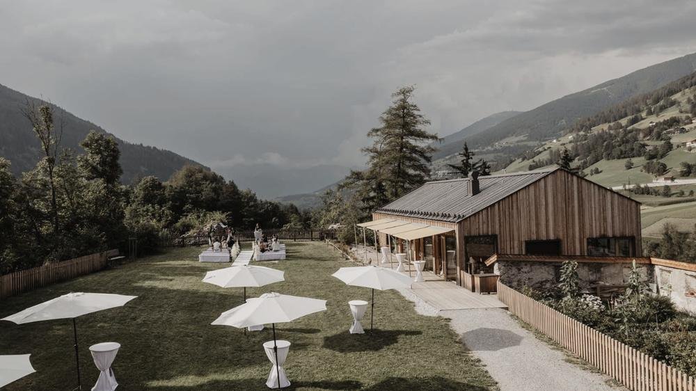 Wiese mit Sonnenschirmen und Blick ins Tal